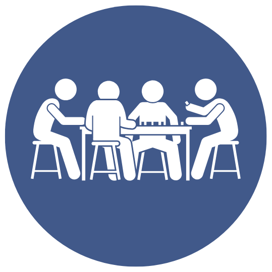 A group of people are sitting in front of a computer screen.