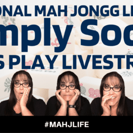 A woman is posing for the camera with her hands on her face.