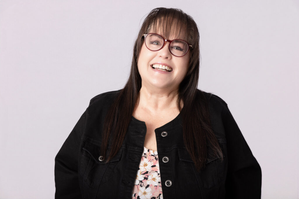 Smiling woman wearing glasses and a jacket.